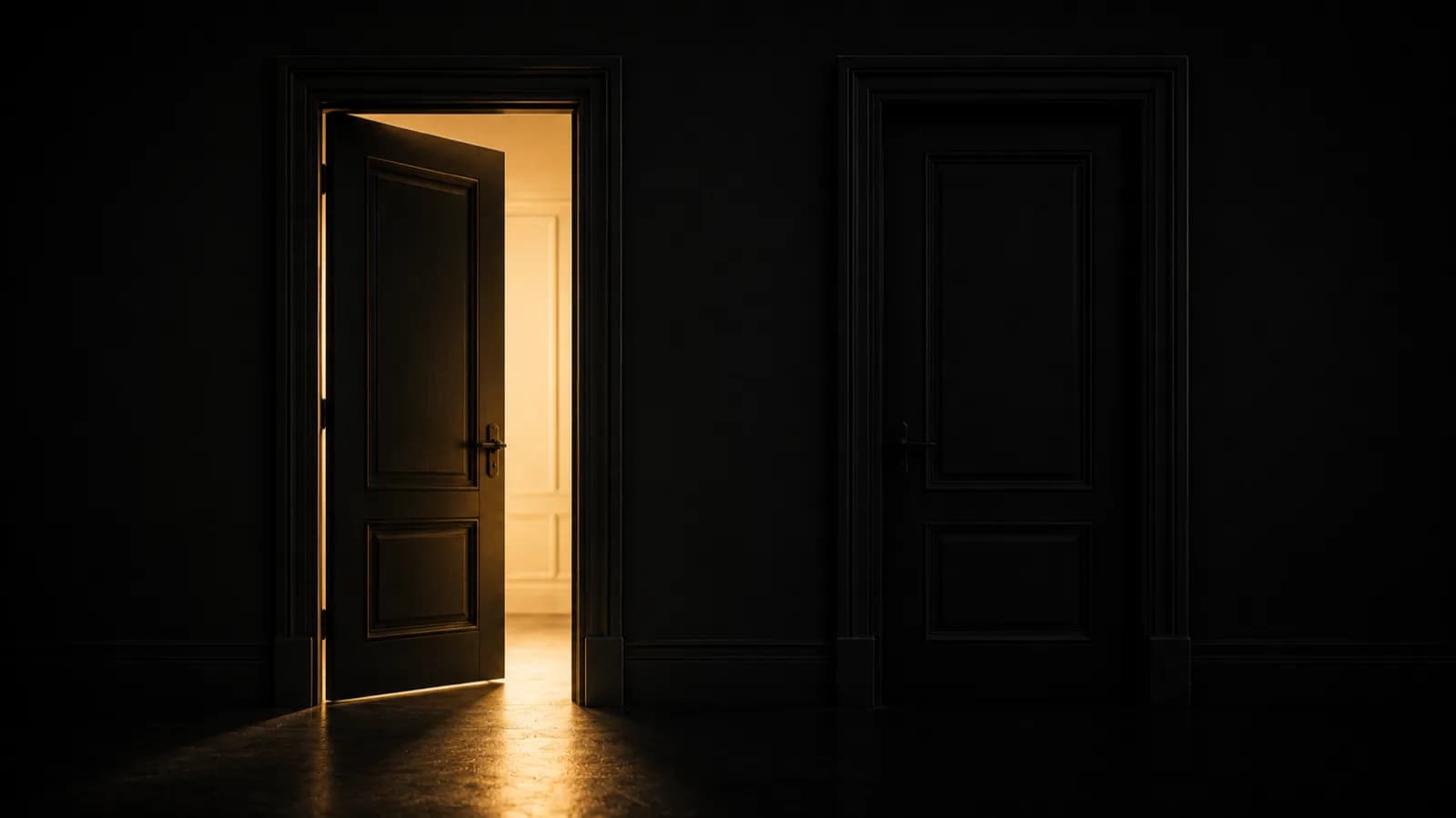Two identical dark doorways side by side, only the left one lit by warm gold light